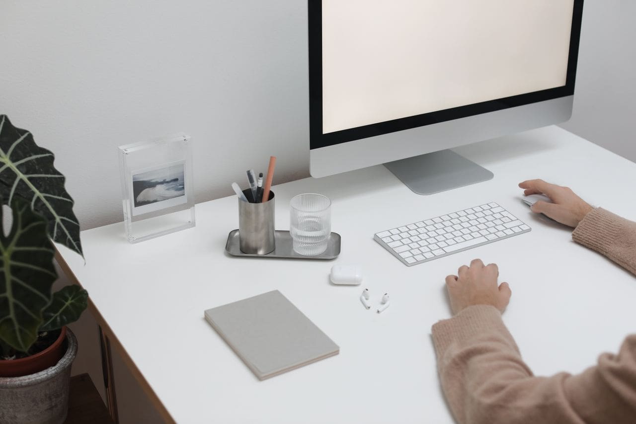 A clean and modern workspace featuring a desktop computer, keyboard, and minimal decor. A clean and modern workspace featuring a desktop computer, keyboard, and minimal decor.
