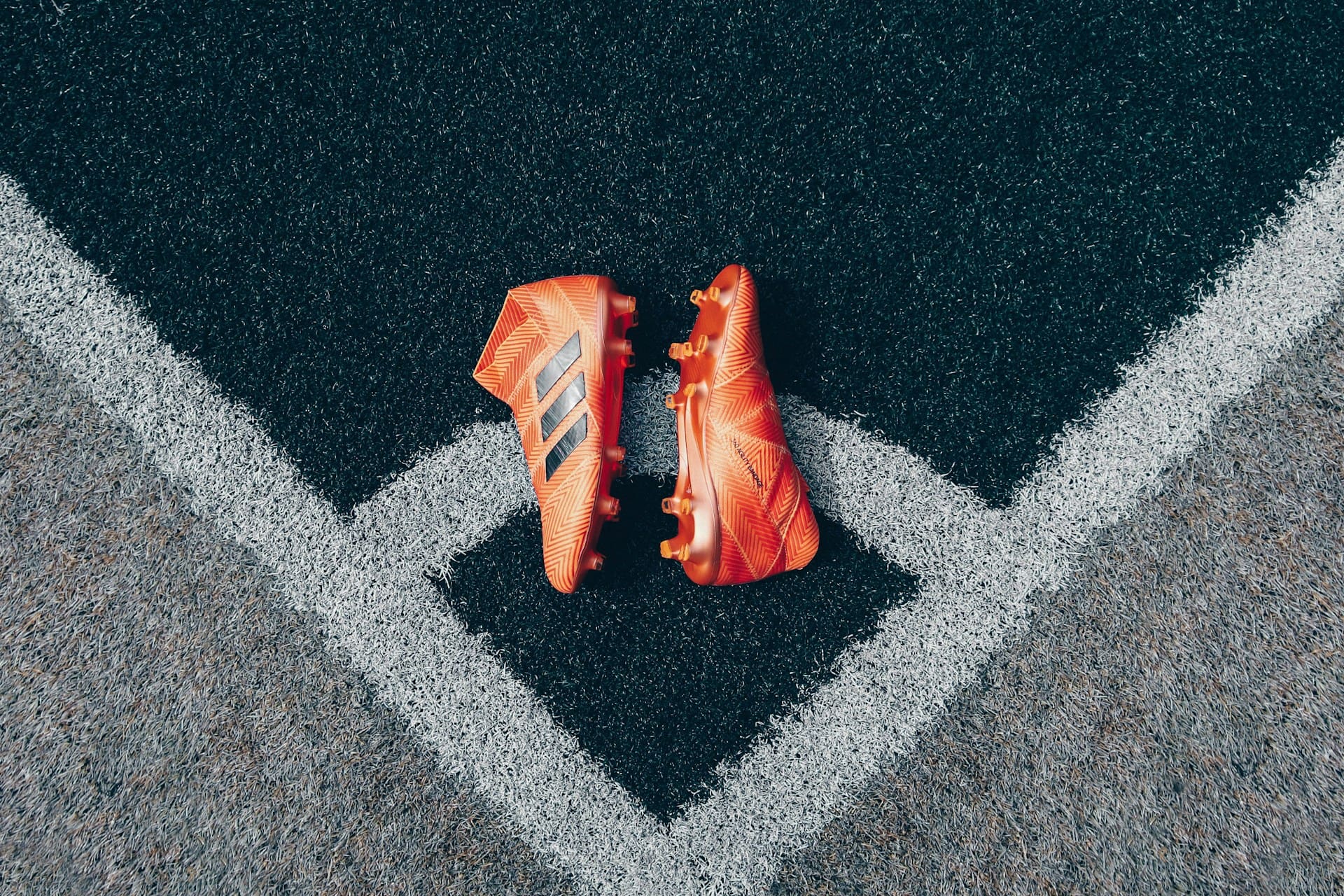 pair of orange adidas cleats on gray surface pair of orange adidas cleats on gray surface