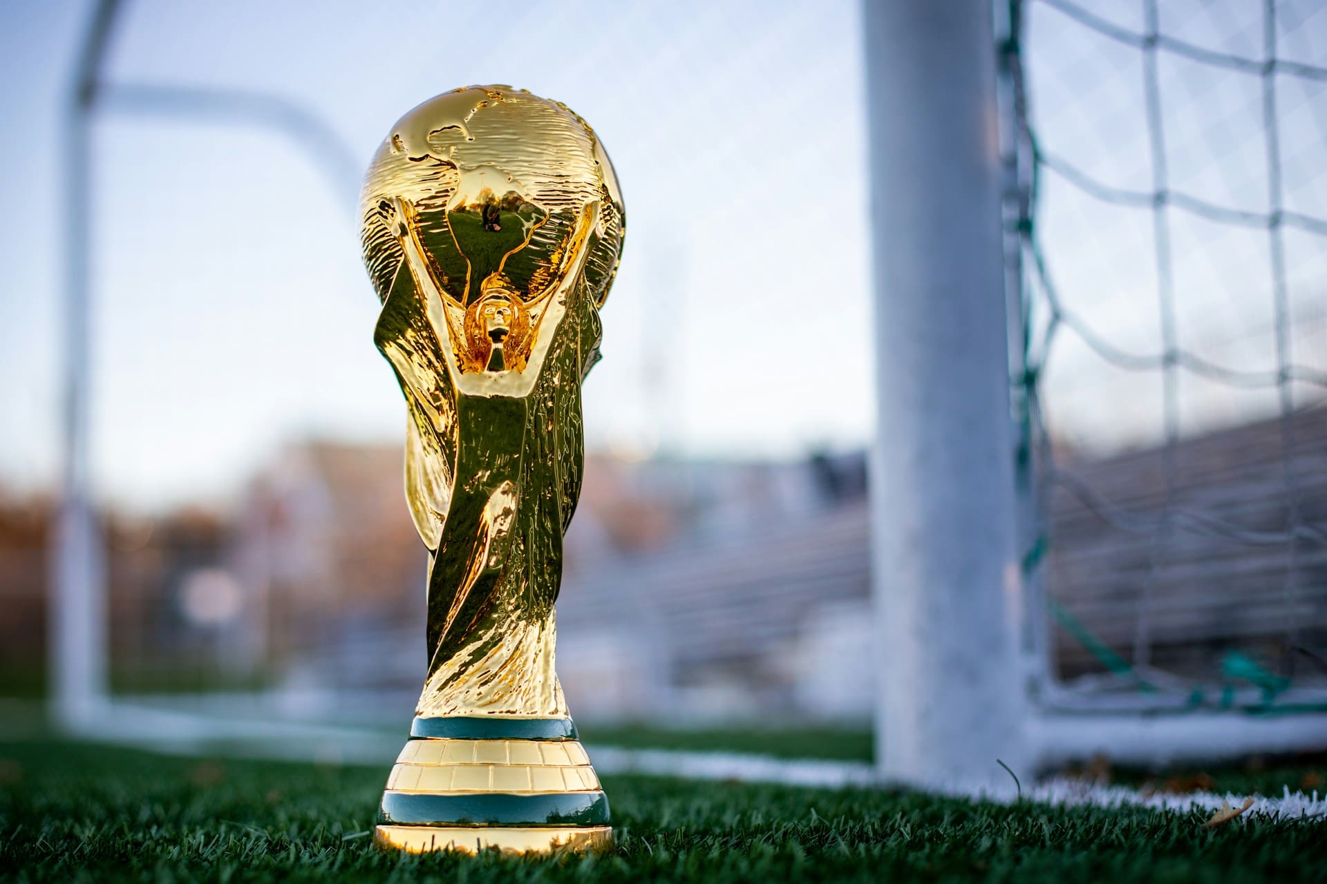 a golden soccer trophy sitting on top of a field a golden soccer trophy sitting on top of a field